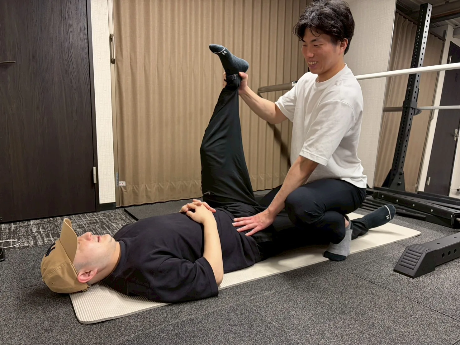 トレーナーがストレッチをサポートしているマンツーマン指導シーン