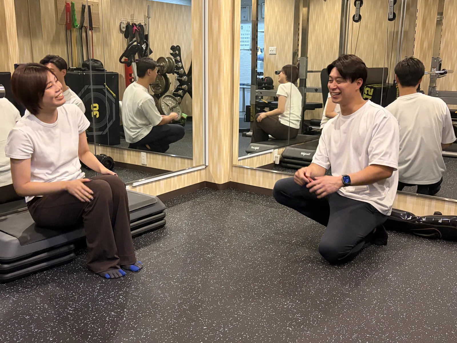 トレーニングスタジオで、トレーナーがお客様と向き合ってカウンセリングをしている様子