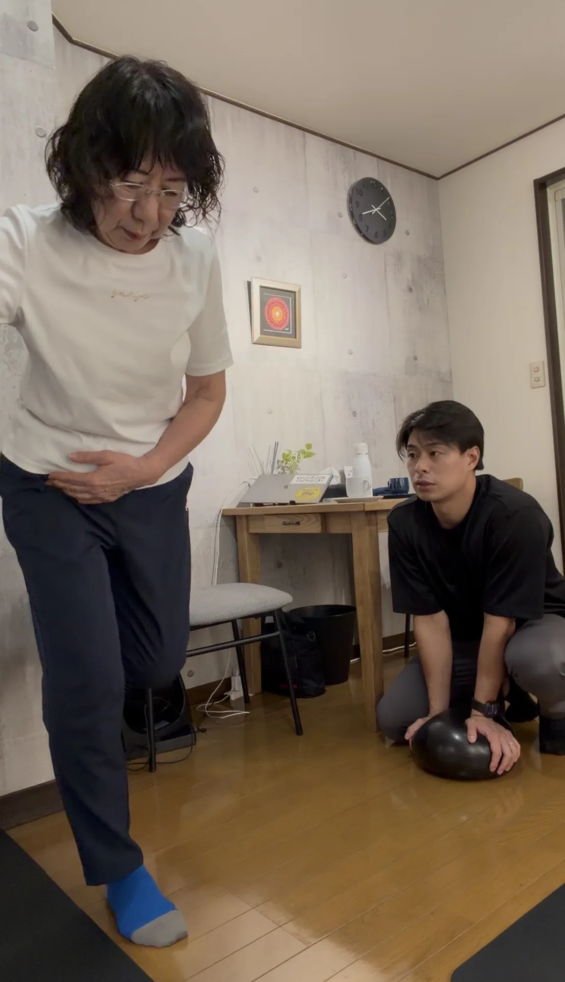 立った姿勢での動きを、トレーナーがすぐ横に付いて確認している様子