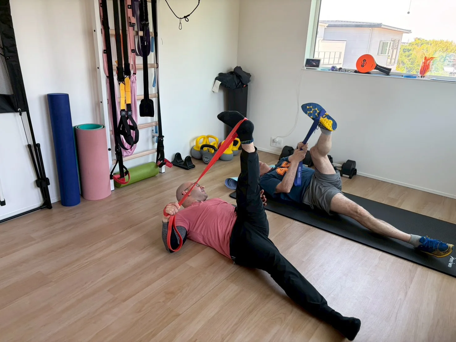 English-speaking trainer and client doing a dynamic side-plank exercise together during an in-home personal training session