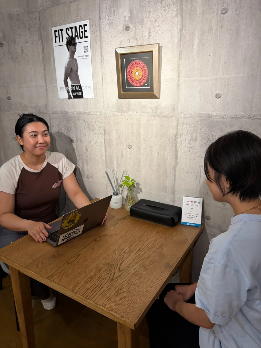 テーブル席でノートパソコンを開き、目標や体の不安を聞き取る様子 — FIT STAGE江坂店
