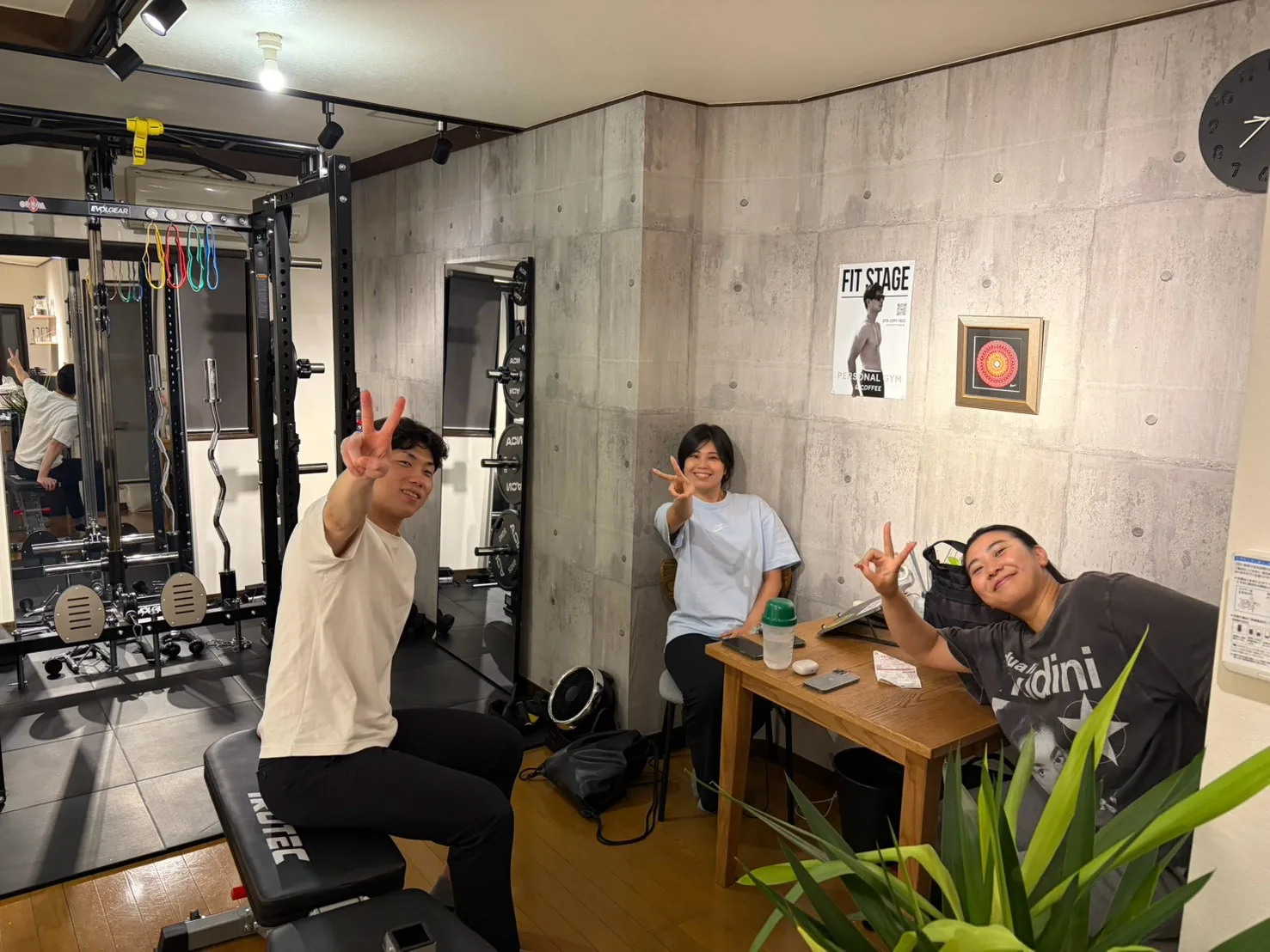 FIT STAGE 江坂店のトレーニングルームで、ピースサインをして笑顔を見せる3人