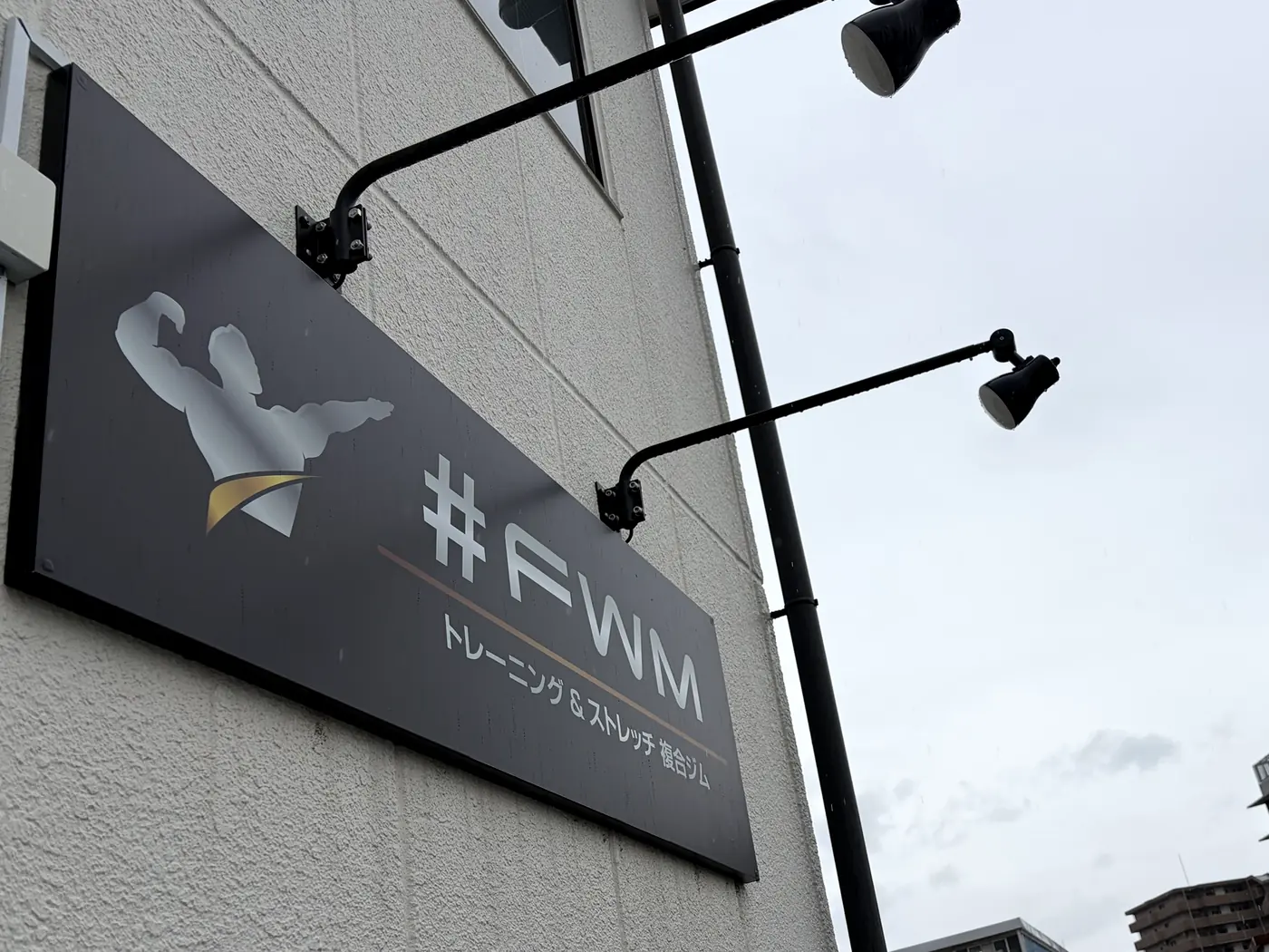 FIT STAGE 庄内店が入る建物の壁面看板。「#FWM」と表示されている