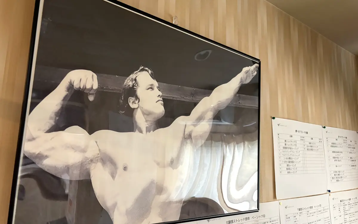 FIT STAGE 曽根城山店の壁面。額装写真とトレーニング資料が掲げられている